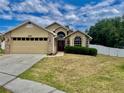 Charming one-story home featuring a two-car garage, brick accents, and a well-manicured lawn at 1980 Aquarius Ct, Oviedo, FL 32766