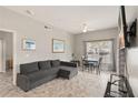 Cozy living room featuring a gray sofa, dining table, and a view from the window at 2204 San Vittorino Cir # 102, Kissimmee, FL 34741