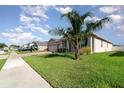 A sunny shot of a well-maintained home featuring a palm tree and a lush green lawn at 2249 Palmetum Loop, Apopka, FL 32712