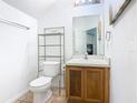 Compact half bathroom features a vanity and toilet with shelving at 2662 Mayaguana St, Kissimmee, FL 34747