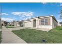 Single-Gathering home featuring a two-car garage, neutral color palette, and manicured front lawn at 269 St Georges Cir, Eagle Lake, FL 33839