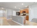Bright kitchen featuring an island with sink, tile backsplash, and wooden cabinets at 269 St Georges Cir, Eagle Lake, FL 33839