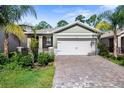 Charming home with a two-car garage, brick driveway, and beautiful landscaping at 280 Caryota Ct, New Smyrna Beach, FL 32168