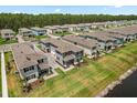 Aerial view of a lakeside community, showcasing well-maintained homes and landscaping with trees at 3039 Meleto Blvd, New Smyrna Beach, FL 32168