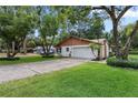 Home exterior features a side-entry garage, long driveway, and lush green lawn at 360 Pineview St, Altamonte Springs, FL 32701