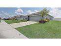 Street view of a well-maintained home featuring a two-car garage and landscaped front yard at 392 Citrine Loop, Kissimmee, FL 34758