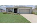 Charming single-story home featuring a well-manicured lawn and an attached two-car garage at 392 Citrine Loop, Kissimmee, FL 34758