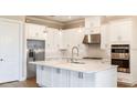 Modern kitchen featuring white cabinets, stainless steel appliances, and a center island at 4209 Barbuda Ln, Kissimmee, FL 34758