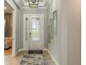 Elegant entryway with decorative door, patterned tile floor, stylish rug, and modern wall decor at 4215 Barbuda Ln, Kissimmee, FL 34758