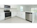 Modern kitchen featuring stainless steel appliances, white cabinets, and a center island with sink at 491 Wayland Dr, Haines City, FL 33844