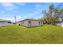 Spacious backyard featuring a well-maintained lawn and views of the home's rear exterior at 508 Churchill Pl, Poinciana, FL 34759
