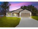 Charming single-story home featuring a two-car garage, well-manicured lawn, and neutral-toned exterior at 508 Churchill Pl, Poinciana, FL 34759