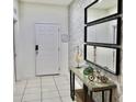 Bright, tiled entryway adorned with decorative mirrors and a console table, creating a welcoming ambiance at 5273 Oakbourne Ave, Davenport, FL 33837