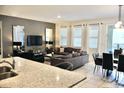 Open-concept living space featuring modern decor, a dining area, and plenty of natural light at 5273 Oakbourne Ave, Davenport, FL 33837