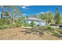 A cozy single-story home surrounded by lush landscaping and mature trees, offering privacy and serenity at 5505 W Magnolia Ave, Port Orange, FL 32127