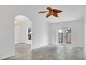 Spacious living room with light tile flooring, arched doorways and access to the backyard through glass doors at 5505 W Magnolia Ave, Port Orange, FL 32127