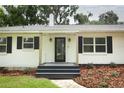 Inviting front entrance with a stylish door, sconces, and decorative landscaping at 656 Lake Charm Dr, Oviedo, FL 32765