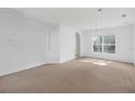 Bright, open living room with neutral carpet, white walls, and ample natural light at 672 Reindeer Dr, Kissimmee, FL 34759