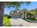 Charming one-story home featuring an arched entryway, a two-car garage, and a mature shade tree at 7201 Halton Ct, Windermere, FL 34786