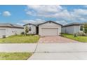 Cozy single-Gathering home showcasing a brick driveway and landscaped front yard at 856 Teton St, Haines City, FL 33844