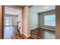 Bright open-concept living space boasts hardwood floors, a staircase, and access to an outdoor area with a pool at 9917 Summerlake Groves St, Winter Garden, FL 34787