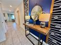 Inviting hallway with stylish decor elements, including a decorative table, lamps, and a round mirror at 1077 Leader St, Davenport, FL 33896