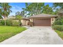 Spacious home featuring an attached garage, lush lawn, and beautiful landscaping at 11 Huntley Ct, Haines City, FL 33844