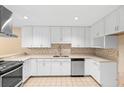Well-lit kitchen with white cabinetry, stainless steel appliances, and ample counter space at 11 Huntley Ct, Haines City, FL 33844