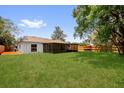Expansive backyard featuring lush lawn, a screened patio and a classic wooden fence at 1301 Paradise Ln, Winter Park, FL 32792