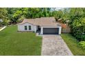 Inviting single-story home showcasing a well-manicured lawn and a convenient two-car garage at 1301 Paradise Ln, Winter Park, FL 32792