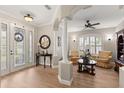 Welcoming foyer with decorative glass door, columns, and hardwood floors leading to the living areas at 141 Dommerich Dr, Maitland, FL 32751