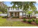 Inviting two-story home with stone accents, a well-manicured lawn, and professional landscaping at 141 Dommerich Dr, Maitland, FL 32751