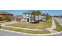 Beautiful two-story home with a well-maintained lawn, palm trees, and a sidewalk at 14537 San Lorenzo Dr, Orlando, FL 32820