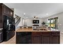 Modern kitchen featuring dark wood cabinets, granite countertops, and stainless steel appliances at 14537 San Lorenzo Dr, Orlando, FL 32820