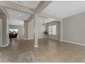 Bright, open-concept living area with tile flooring, neutral paint, and elegant support beams at 14537 San Lorenzo Dr, Orlando, FL 32820