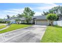 Single-story home with an attached garage and a long driveway, nestled in a neighborhood with mature trees and green lawns at 227 Morning Glory Dr, Lake Mary, FL 32746
