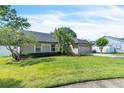Well-maintained single-story home featuring a lush lawn, mature trees, and a two-car garage, offering suburban charm at 227 Morning Glory Dr, Lake Mary, FL 32746