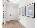 Bright entryway featuring wood floors, white walls, and decorative art at 2294 Gold Dust Dr, Minneola, FL 34715