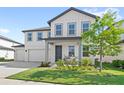 Charming two-story home with white siding, grey trim, landscaped yard, and a welcoming front porch at 2294 Gold Dust Dr, Minneola, FL 34715