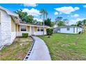 Well-maintained home exterior showcases a green lawn, walkway to entry, and mature landscaping at 2809 Pioneer Rd, Orlando, FL 32808