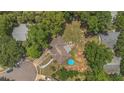 Expansive aerial view of property highlighting roof, backyard patio, above-ground pool, and surrounding lush greenery at 300 Hickory Ct, Apopka, FL 32712