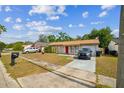 Single-story home with a red front door and driveway with vehicles parked in front at 3711 Shady Grove Cir, Orlando, FL 32810