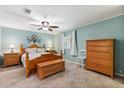 Charming bedroom with wood furniture, ceiling fan, and a decorative tree of life wall decoration at 38 Da Rosa Ave, Debary, FL 32713