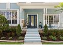 Inviting front porch with blue door, columns, and manicured landscaping at 4608 Atwood Dr, Orlando, FL 32828