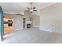 Open-concept living room with fireplace, tile floors, and views into kitchen at 622 Tomlinson Ter, Lake Mary, FL 32746