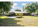 Beautiful one-story brick home with a metal roof and a circular garden at 949 Shadow Oaks Rd, Kissimmee, FL 34744