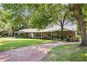 A spacious one-story brick home with a long driveway and lush landscaping at 949 Shadow Oaks Rd, Kissimmee, FL 34744