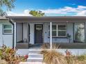 Enclosed front porch with a decorative door, steps to the house and plants in front at 9506 Number Two Rd, Howey In The Hills, FL 34737