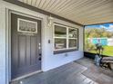 Enclosed front porch with a decorative door, light fixture, and view of the yard and blue storage shed at 9506 Number Two Rd, Howey In The Hills, FL 34737