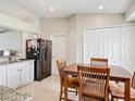 Eat-in kitchen featuring white cabinets, tile floors and stainless steel refrigerator at 970 Courtland Blvd, Deltona, FL 32738
